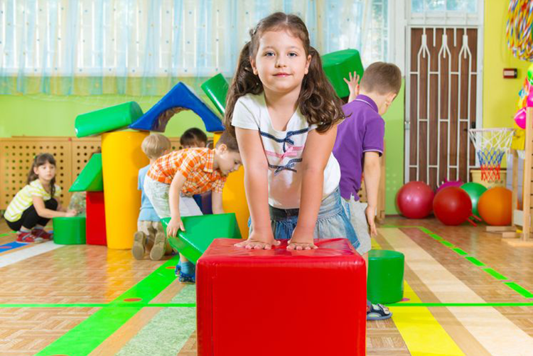 A girl playing in a nursery with a group of children