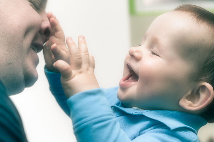 A two year old playing with a male nursery worker.