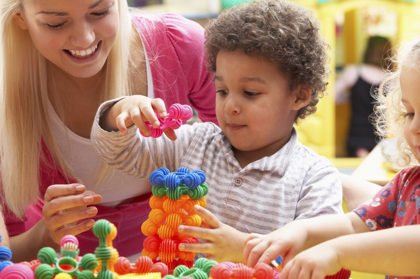 early years worker helping child