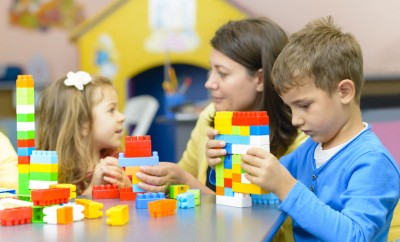 kids playing with plastic building blocks in autism friendly nursery