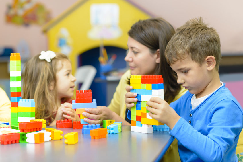 kids playing with plastic building blocks in autism friendly nursery