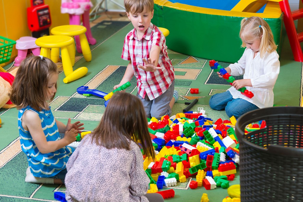 19783570 – group of kids playing with colorful constructor on floor