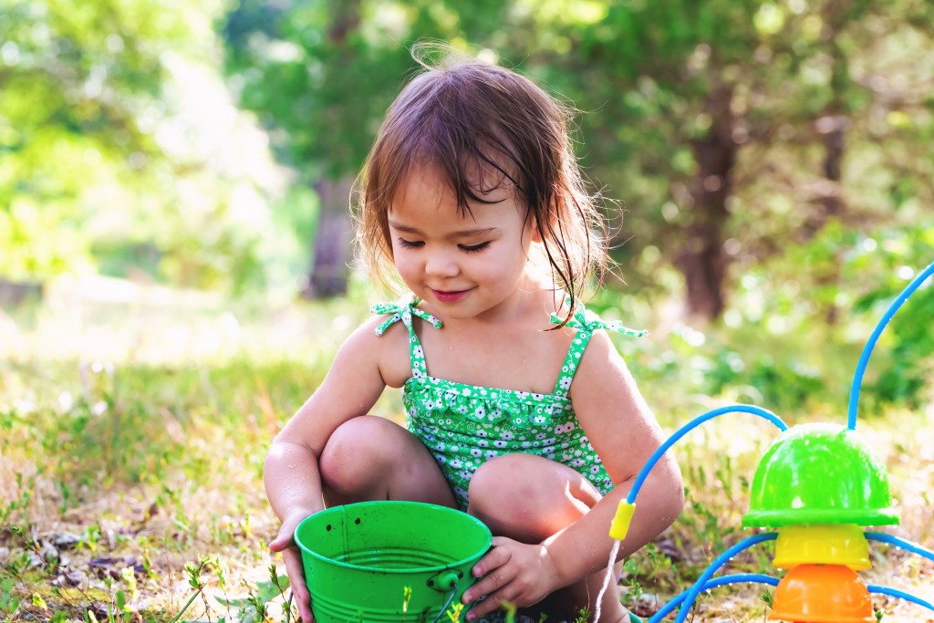 Happy toddler girl playing with water