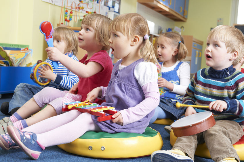 Group Of Pre School Children Taking Part In Music Lesson