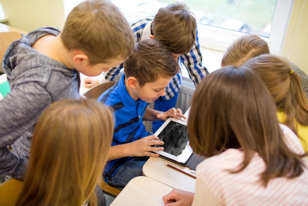 group of school kids with tablet pc in classroom